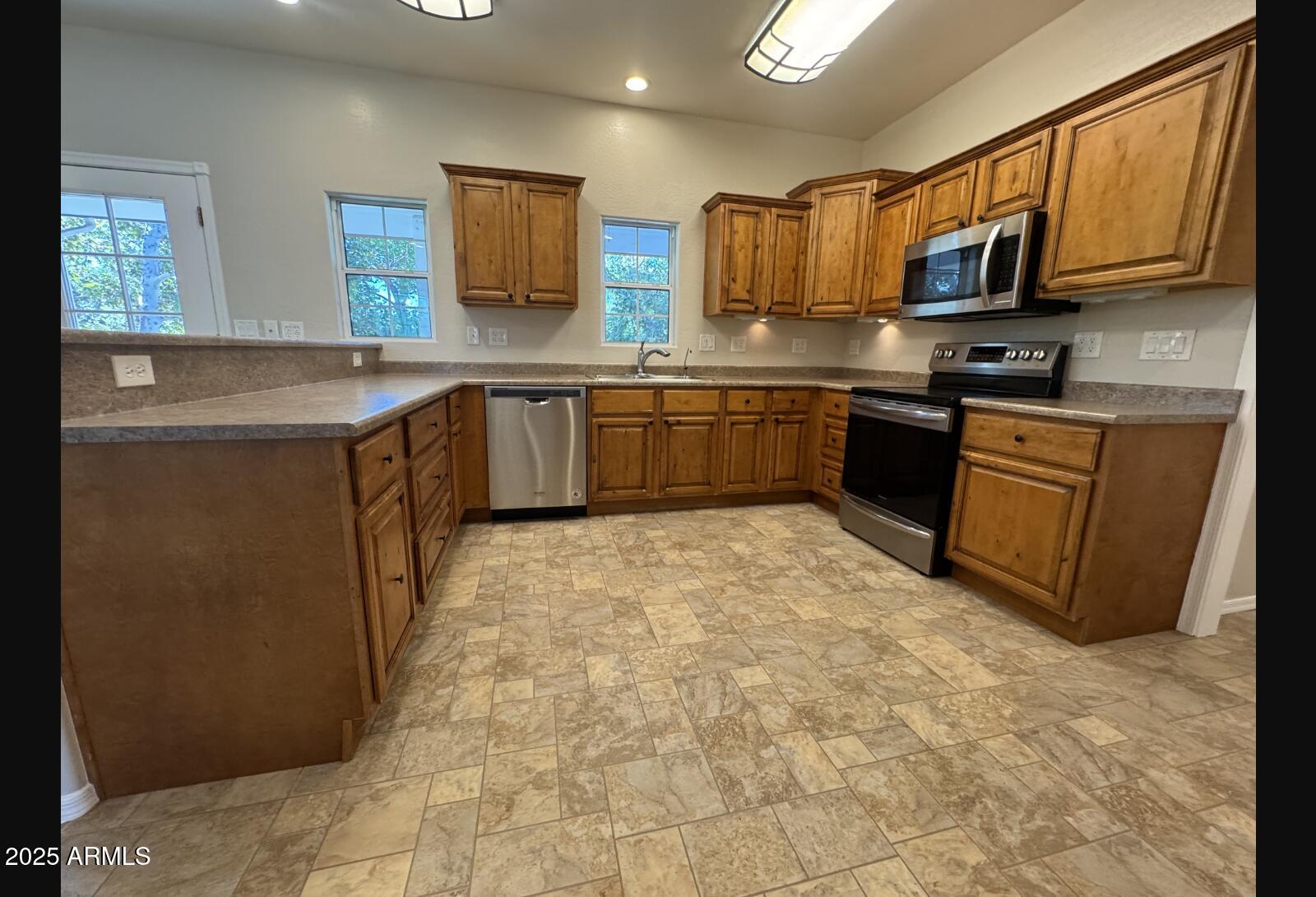 505 Raysun Lane Camp Verde, AZ 86322 - Photo 19 of 50 a kitchen with stainless steel appliances granite countertop a stove a sink a microwave and a refrigerator
