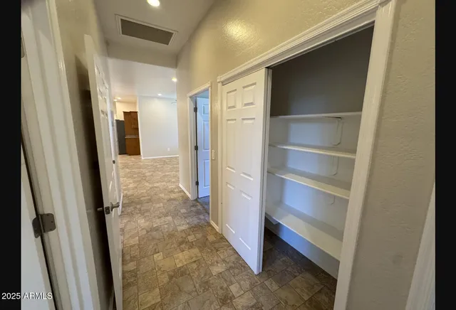 an empty room with windows and fan