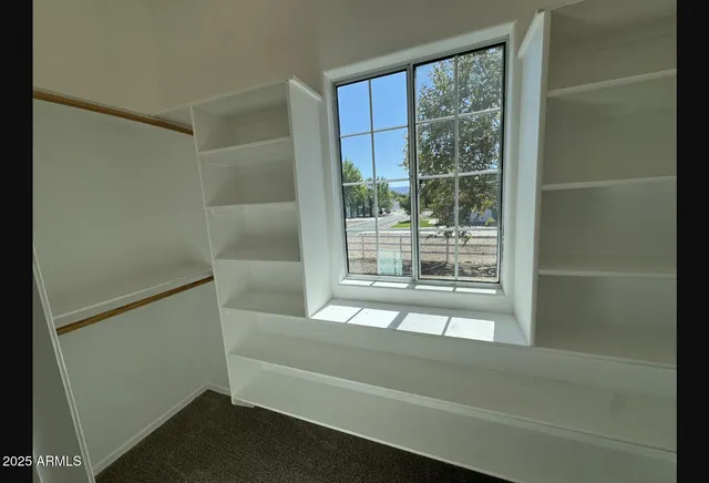 an empty room with windows and closet
