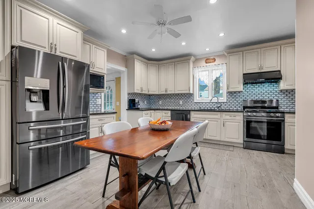 a kitchen with granite countertop a stove refrigerator and microwave