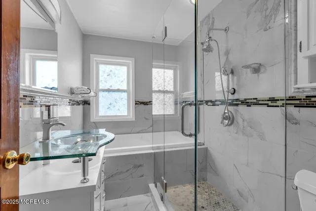 a bathroom with a granite countertop sink mirror and a bathtub