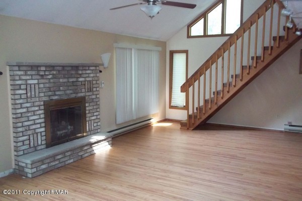 2721-19 Radcliff Road Bushkill, PA 18324 - Photo 2 of 19 a view of an empty room with wooden floor a fireplace and a window