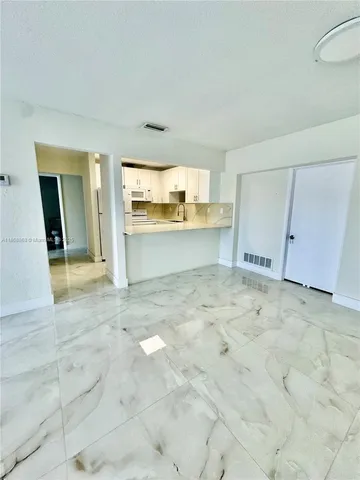 a view of an empty room with window and bathroom view