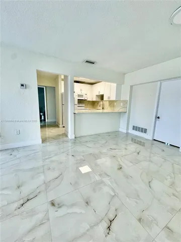 a view of kitchen with granite countertop cabinets and sink