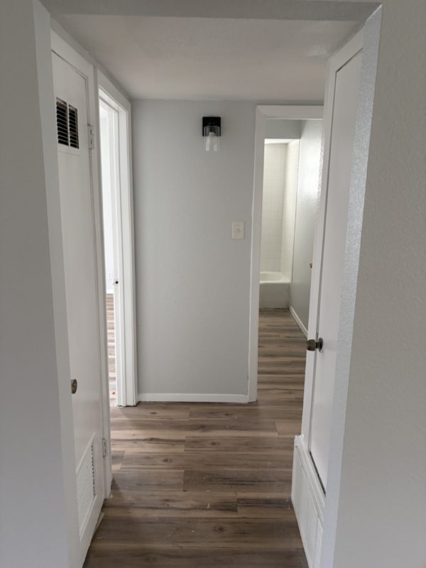 604 West 4th Street Taylor, TX 76574 - Photo 5 of 8 Hallway featuring dark wood-type flooring and baseboards