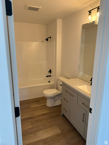1886 North 300 West Logan, UT 84341 - Photo 15 of 18 Contemporary bathroom featuring a white tub/shower combination with matte black fixtures, a single-sink vanity with a light-colored countertop, and wood-finish flooring