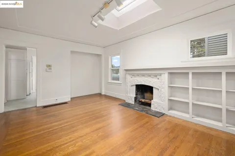a view of a livingroom with a fireplace cabinet and window