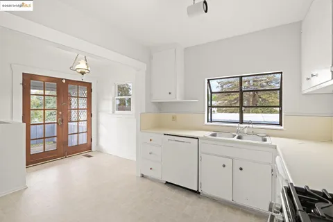 a view of a kitchen with a sink dishwasher cabinets and a window
