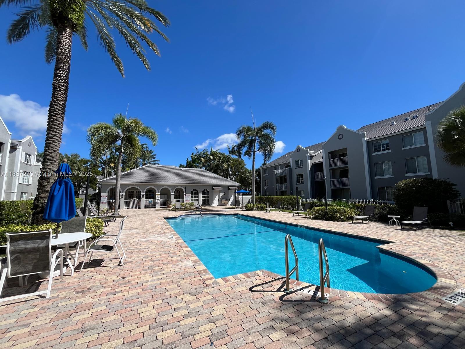 655 Southwest 111th Way, Unit 308 Pembroke Pines, FL 33025 - Photo 2 of 42 a view of a patio with swimming pool table and chairs