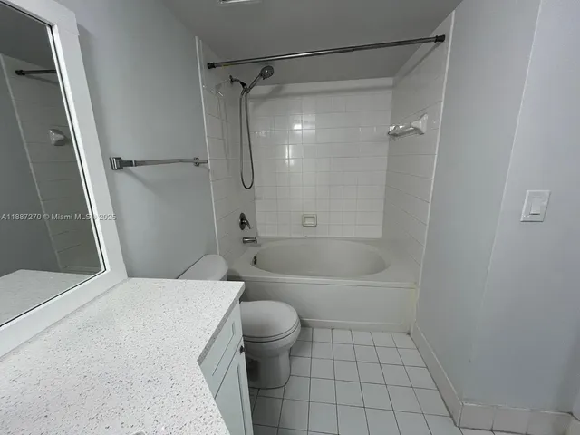 a bathroom with a bathtub shower and toilet