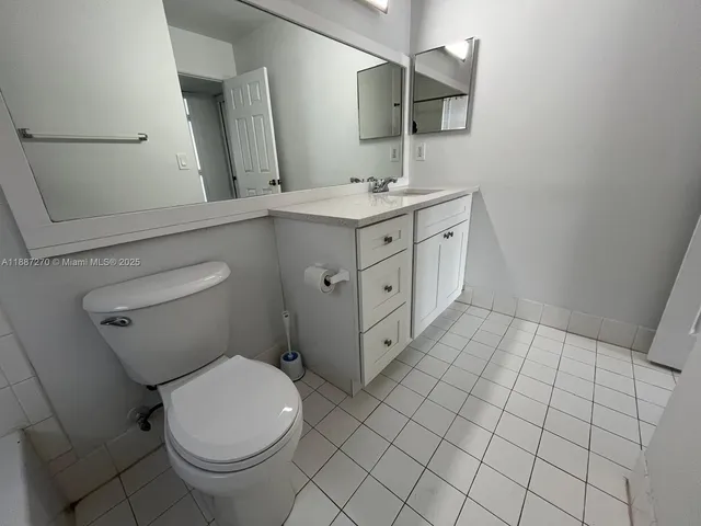 a spacious bathroom with a toilet sink and mirror
