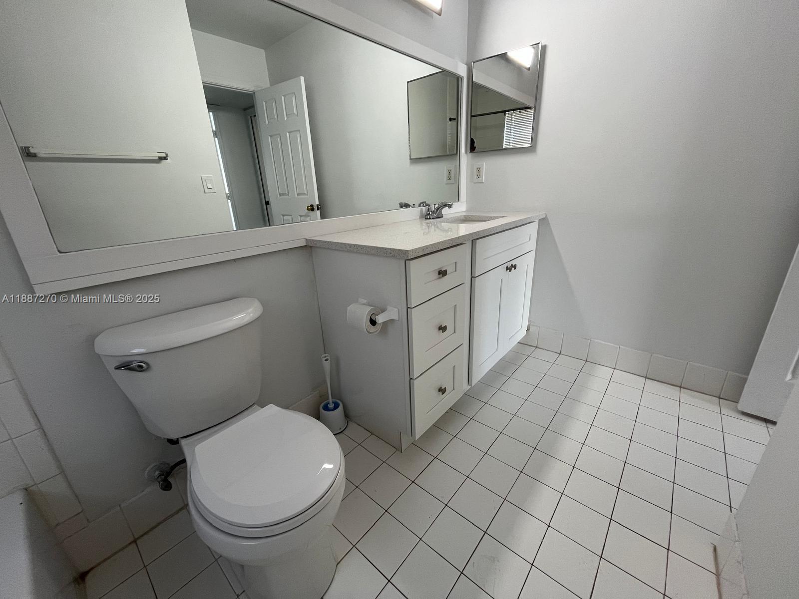 655 Southwest 111th Way, Unit 308 Pembroke Pines, FL 33025 - Photo 24 of 42 a spacious bathroom with a toilet sink and mirror