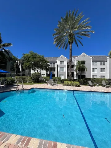 a view of a swimming pool with a chair and tables in the patio