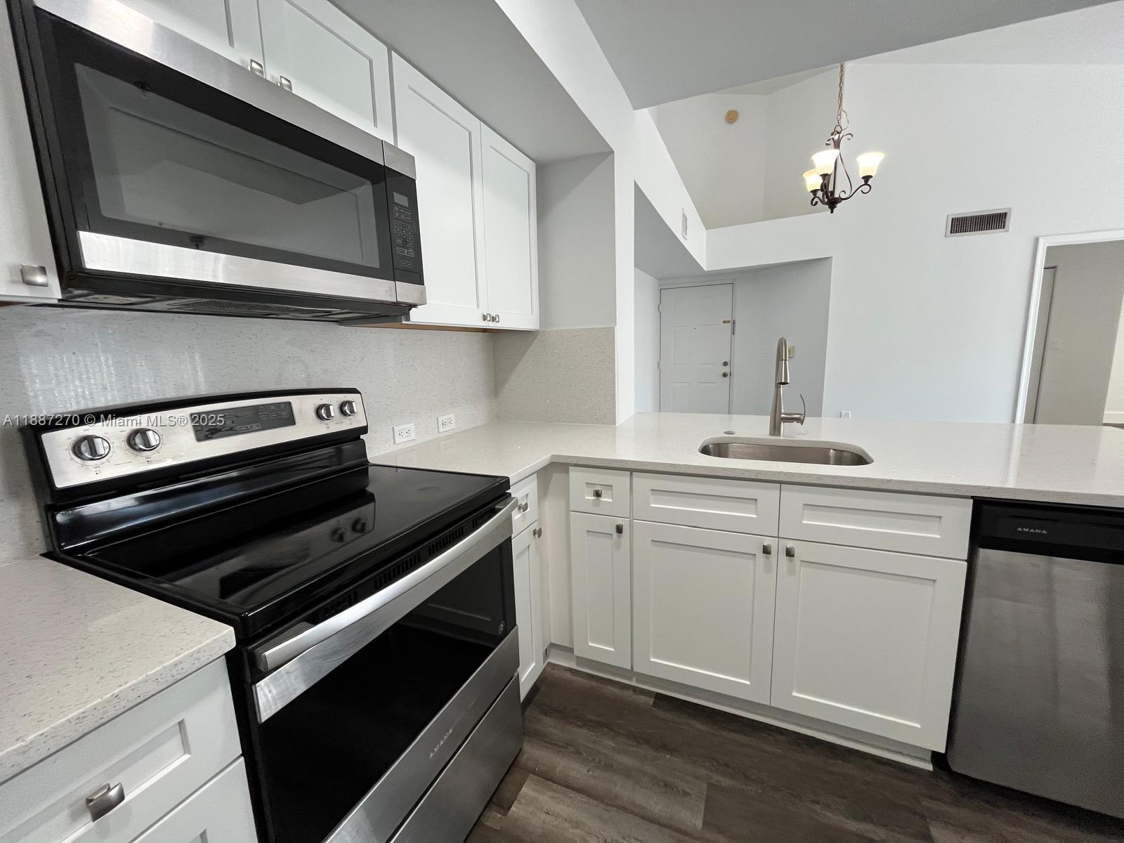 655 Southwest 111th Way, Unit 308 Pembroke Pines, FL 33025 - Photo 7 of 42 a kitchen with a stove microwave and sink