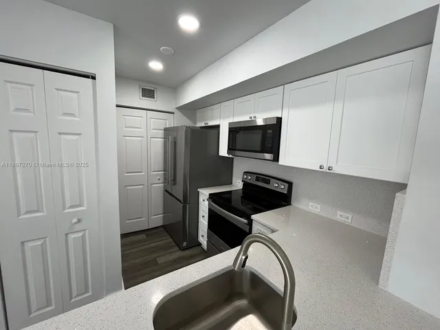a kitchen with stainless steel appliances a refrigerator and a sink