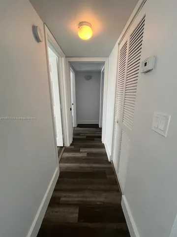a view of a hallway with wooden floor and entryway