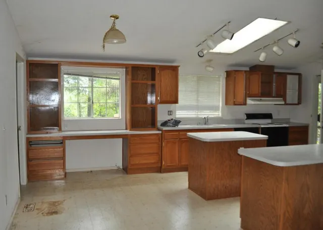 a kitchen with granite countertop a sink and a wooden cabinets
