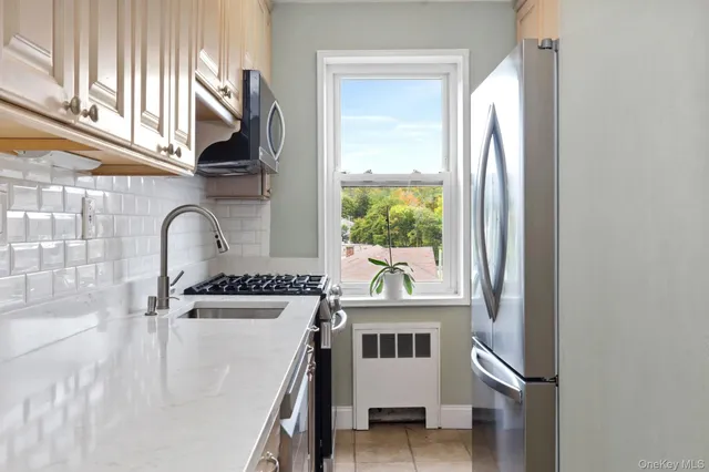 a kitchen with a stove a sink and a window