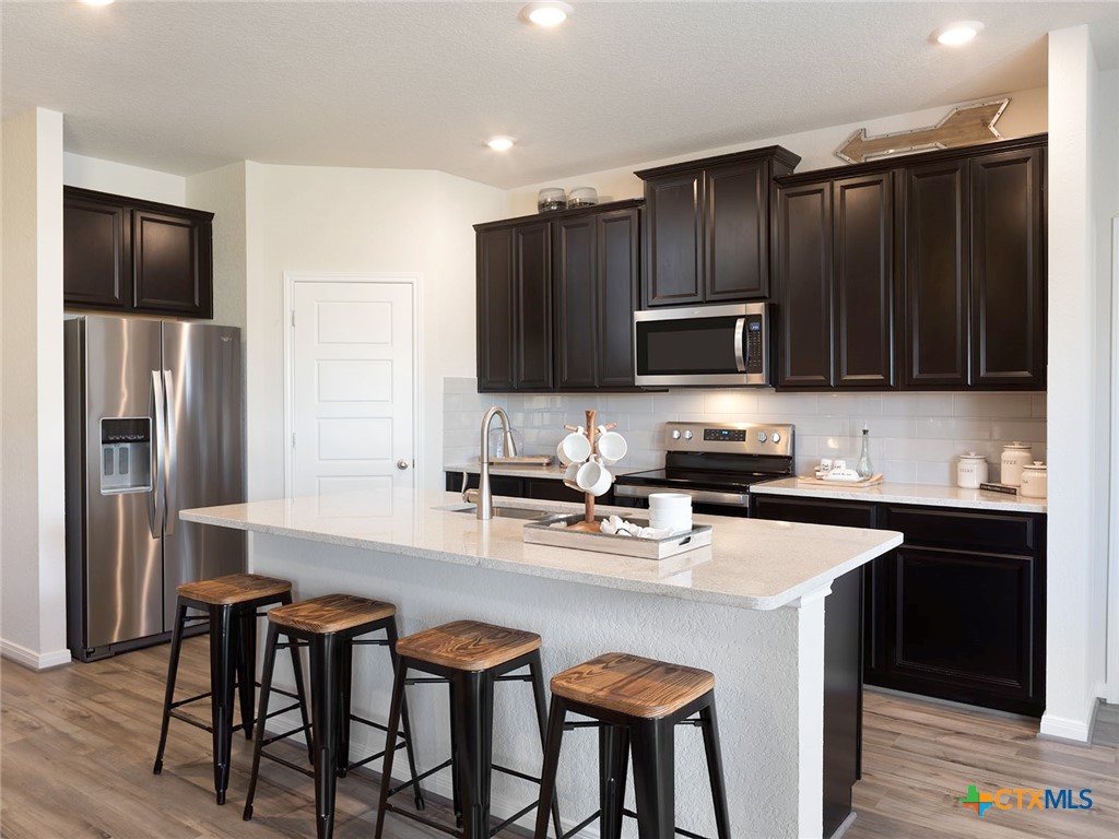 125 Dakota Ridge Cibolo, TX 78108 - Photo 2 of 13 a kitchen with stainless steel appliances wooden cabinets a refrigerator and a stove top oven