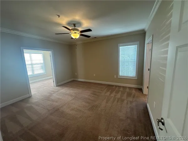 an empty room with windows and fan