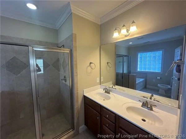 a bathroom with a double vanity sink mirror and shower