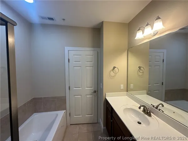 a bathroom with a tub sink and mirror