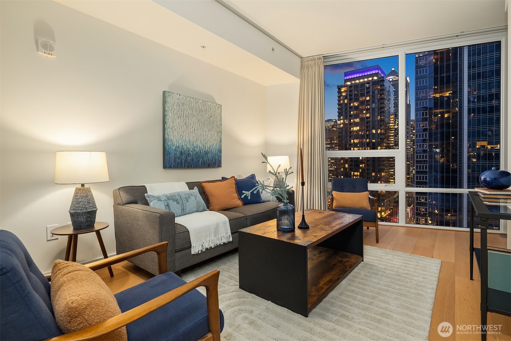 121 Stewart Street, Unit 1803 Seattle, WA 98101 - Photo 16 of 35 a living room with furniture a lamp and a large window