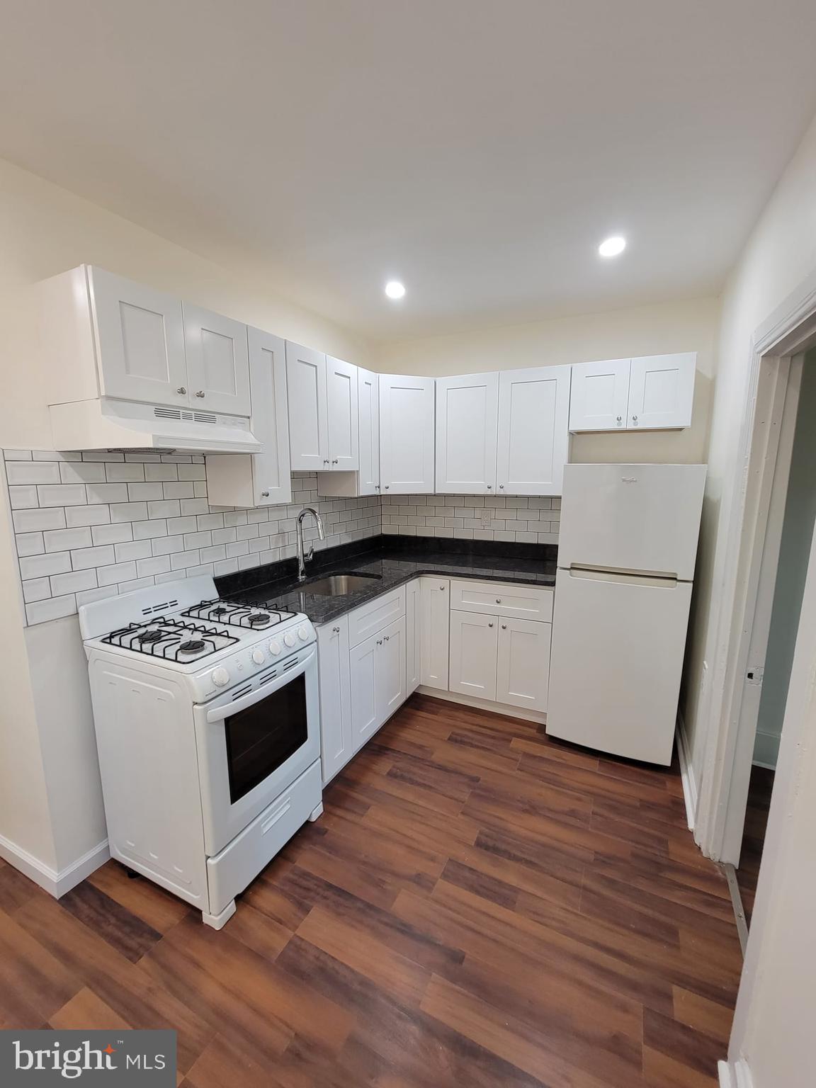 616 Tasker Street, Unit 2 Philadelphia, PA 19148 - Photo 2 of 22 a kitchen with granite countertop a sink and a stove top oven