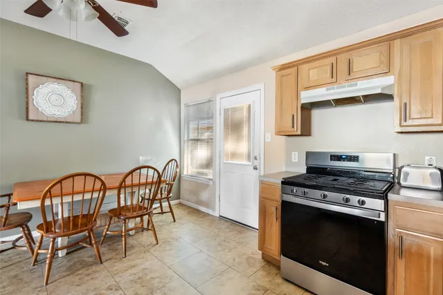 a kitchen with stainless steel appliances a stove a sink and a dining table