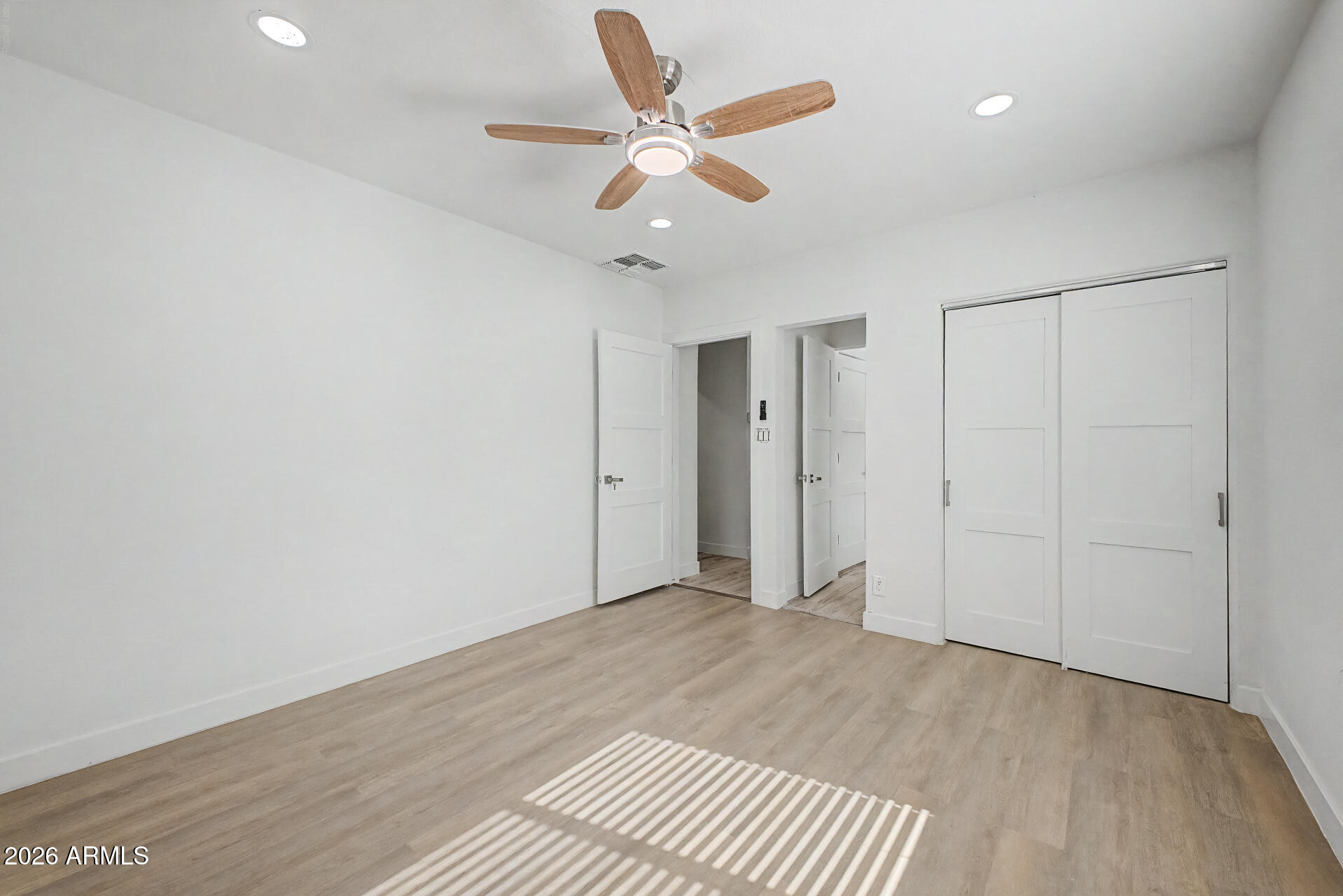 532 East Cheery Lynn Road Phoenix, AZ 85014 - Photo 16 of 37 an empty room with wooden floor and ceiling fan