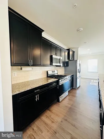 a large kitchen with stainless steel appliances kitchen island granite countertop a stove a sink and a microwave