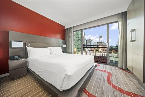 a large bedroom with a bed and wooden floor