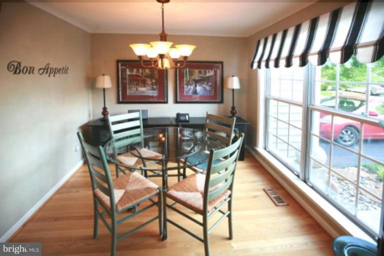 1506 Deer Point Way Reston, VA 20194 - Photo 2 of 30 a view of a dining room with furniture a chandelier window and wooden floor