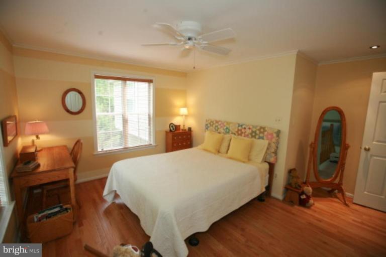 1506 Deer Point Way Reston, VA 20194 - Photo 15 of 30 a bedroom with a bed a dresser next to a window