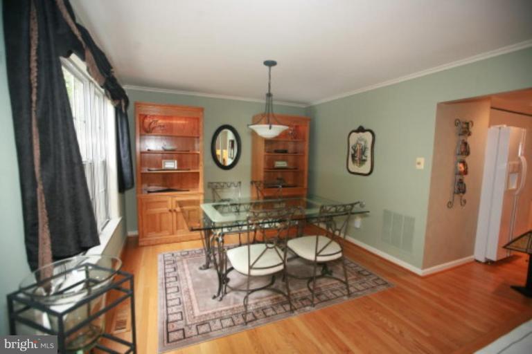 1506 Deer Point Way Reston, VA 20194 - Photo 20 of 30 a living room with chair a clock on wall and a window