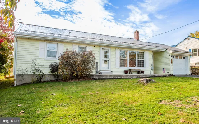 a view of a house with a backyard and a patio