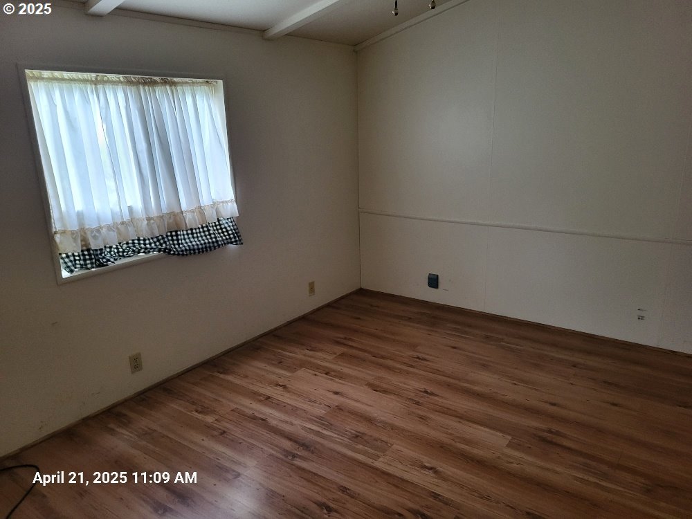 1050 North Cedar Point Road Coquille, OR 97423 - Photo 13 of 29 an empty room with wooden floor and windows