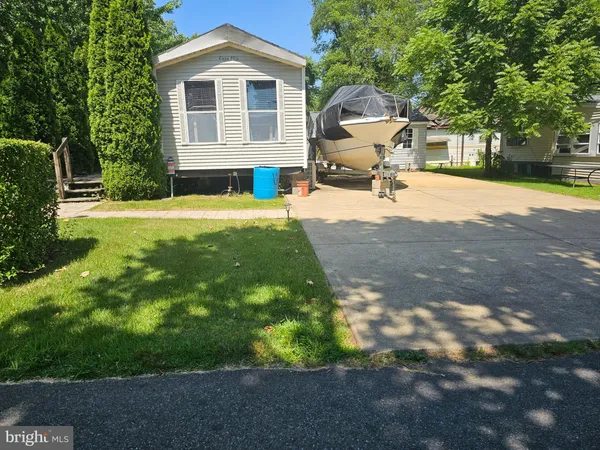 a front view of a house with a garden and a tree