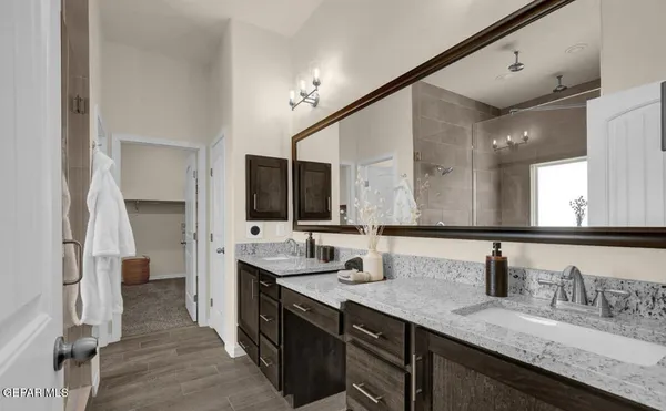 a bathroom with double vanity and a mirror