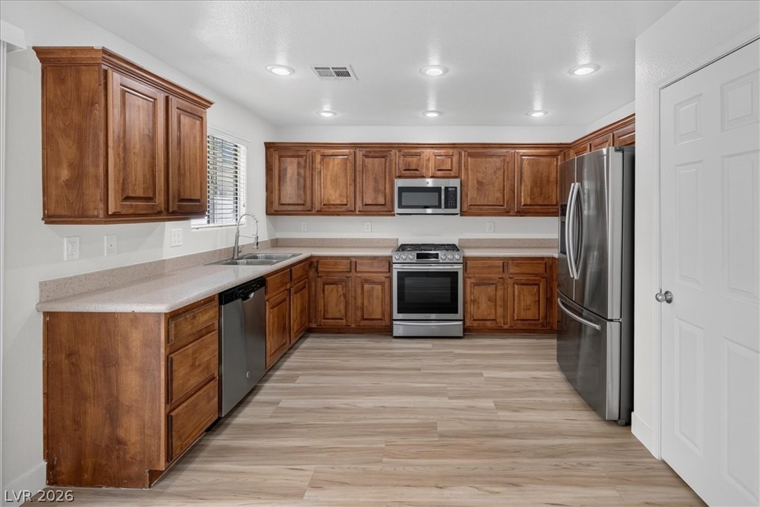 552 Albacate Street Henderson, NV 89015 - Photo 11 of 40 A well-equipped kitchen awaits with abundant wood cabinetry and contemporary stainless steel appliances.