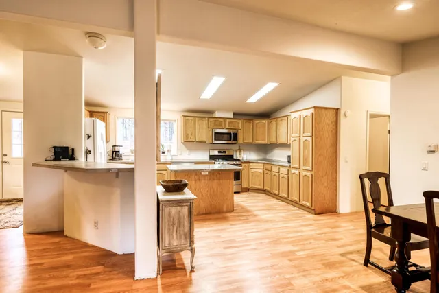 a kitchen with stainless steel appliances granite countertop a sink a stove and cabinets
