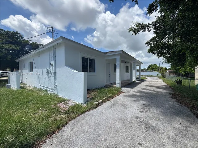 a front view of house with yard and trees around