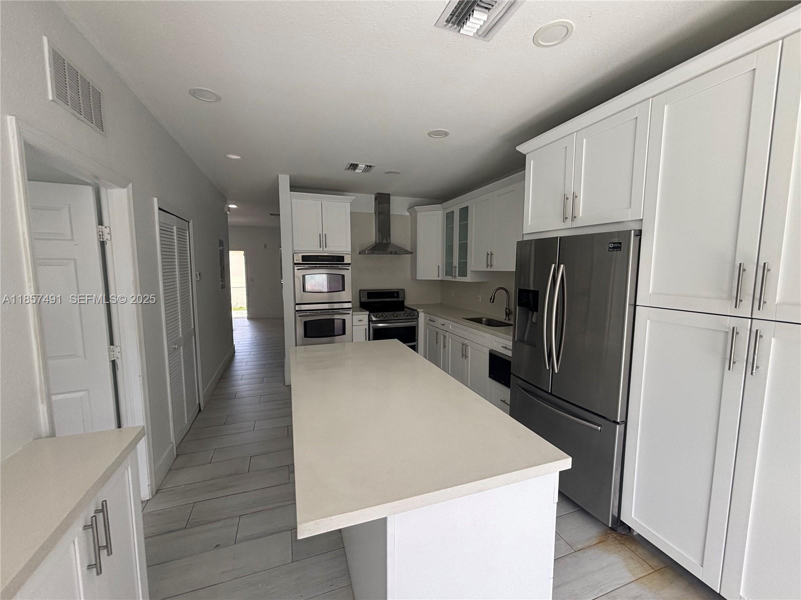 26514 Southwest 138th Avenue, Unit 26514 Homestead, FL 33032 - Photo 6 of 14 a kitchen with stainless steel appliances a refrigerator stove microwave and cabinets