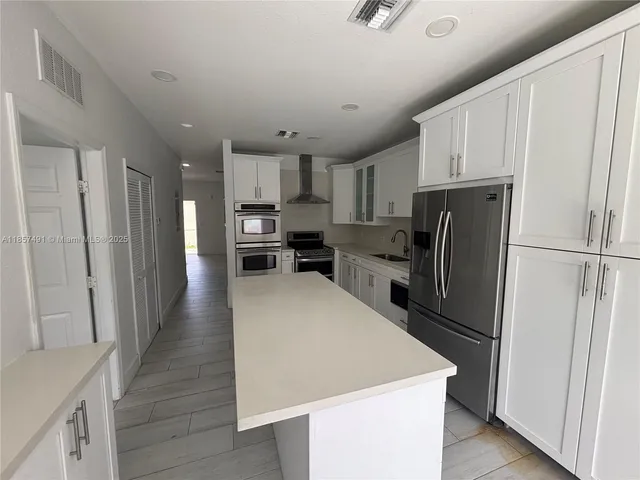 a kitchen with stainless steel appliances a refrigerator stove microwave and cabinets