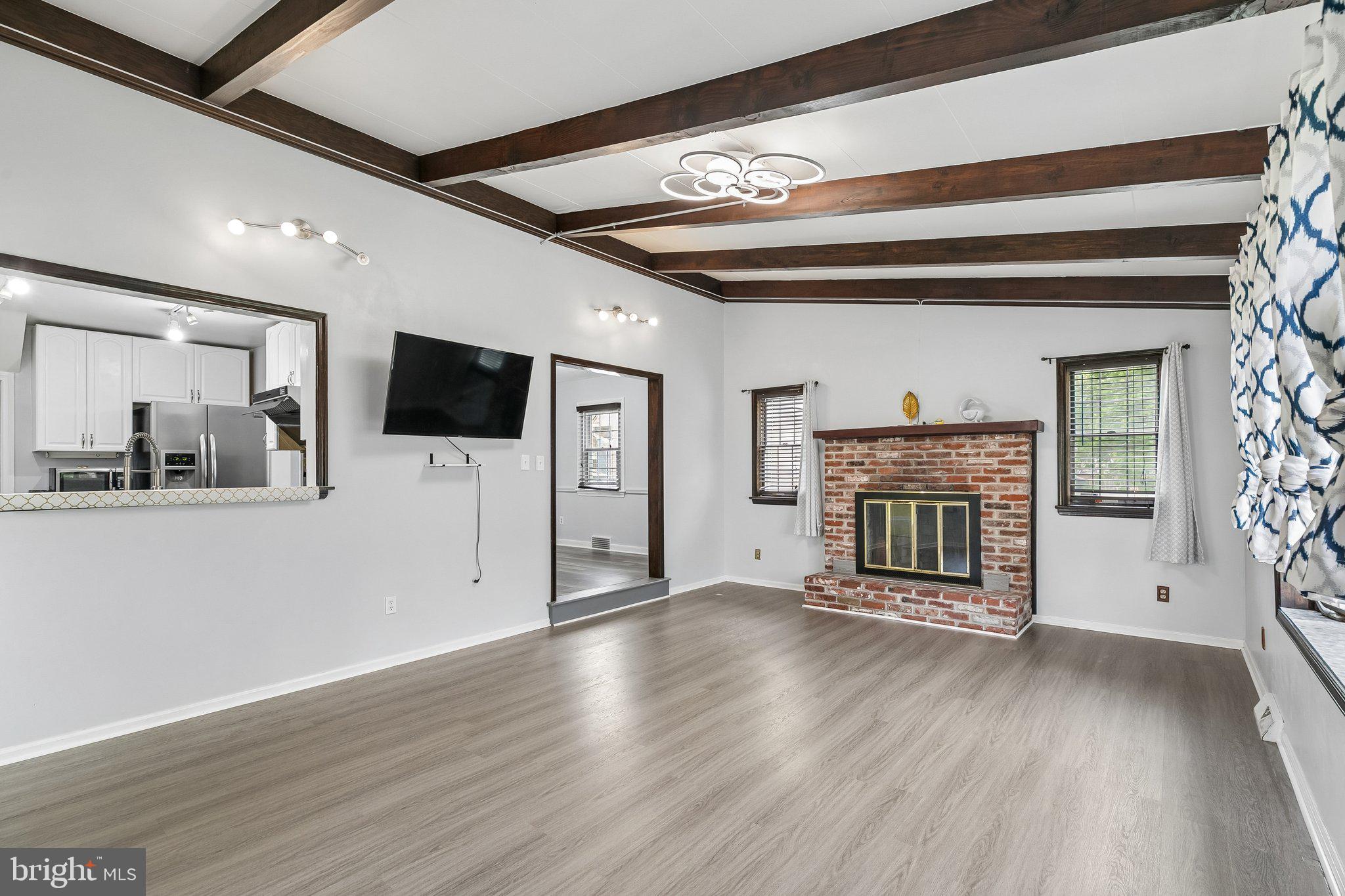 556 Anne Street Huntingdon Valley, PA 19006 - Photo 18 of 50 a view of a livingroom with a fireplace a chair wooden floor and chandelier