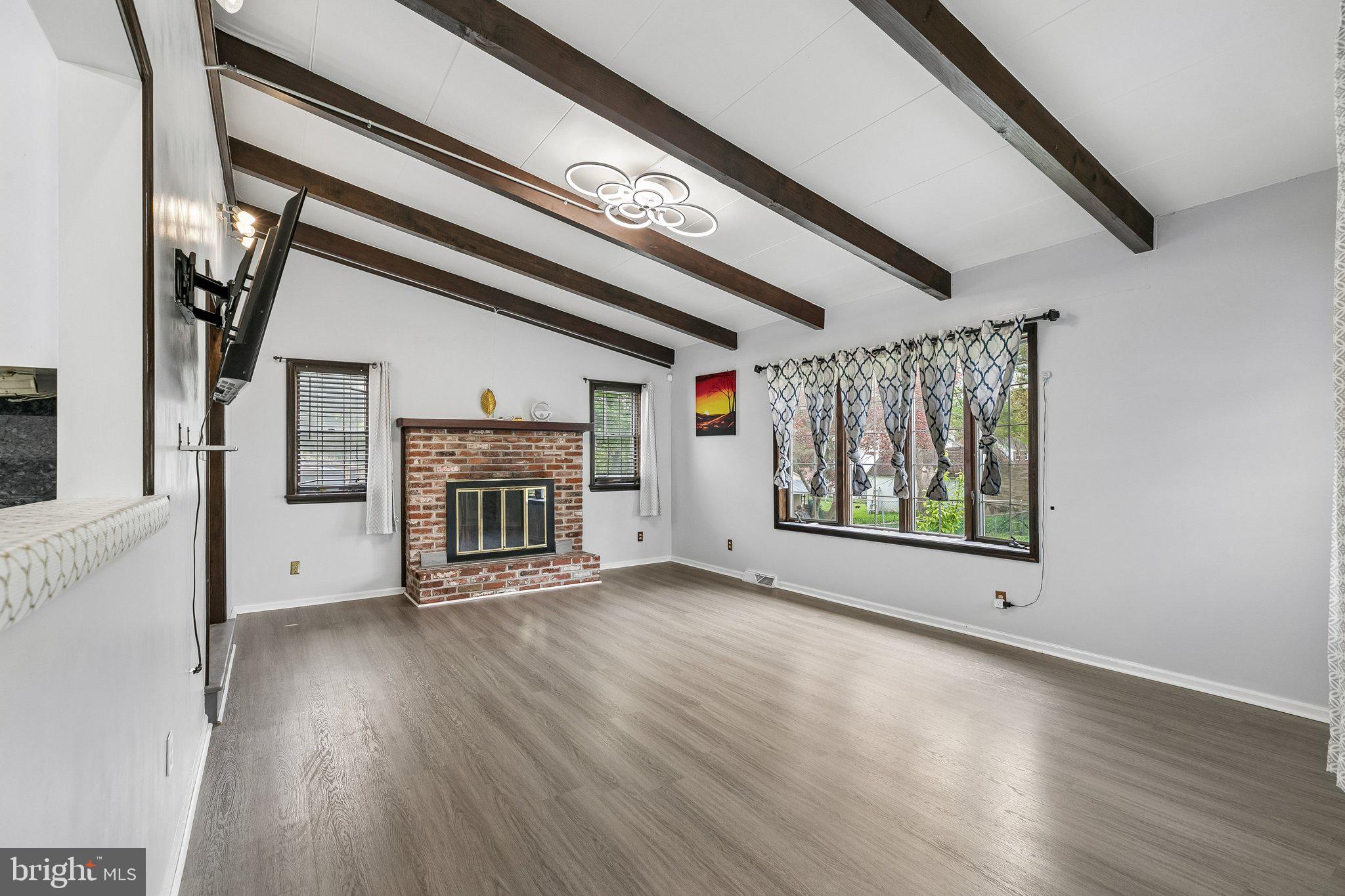 556 Anne Street Huntingdon Valley, PA 19006 - Photo 19 of 50 an empty room with wooden floor fireplace and windows