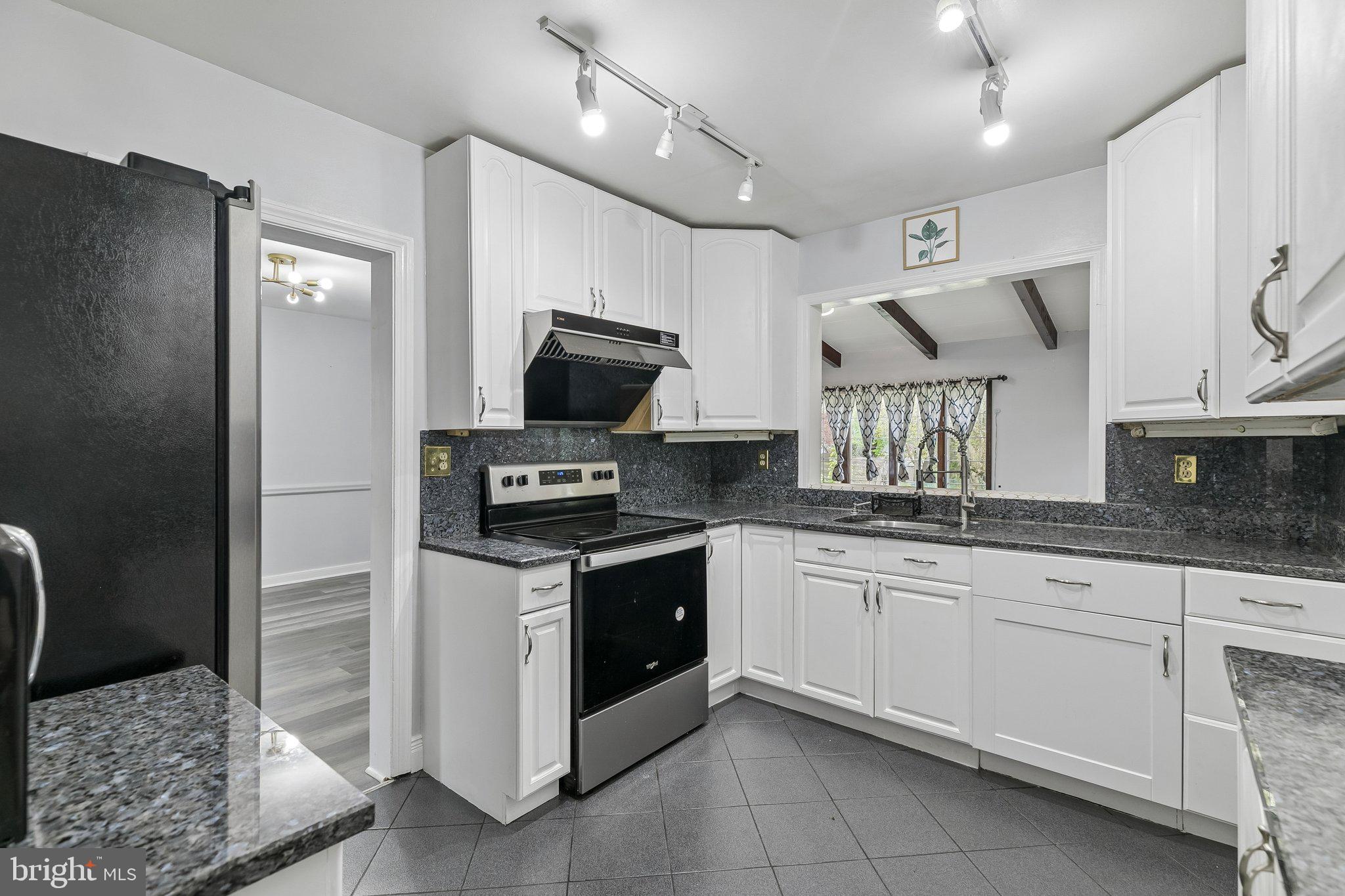 556 Anne Street Huntingdon Valley, PA 19006 - Photo 32 of 50 a kitchen with granite countertop a sink stainless steel appliances and white cabinets