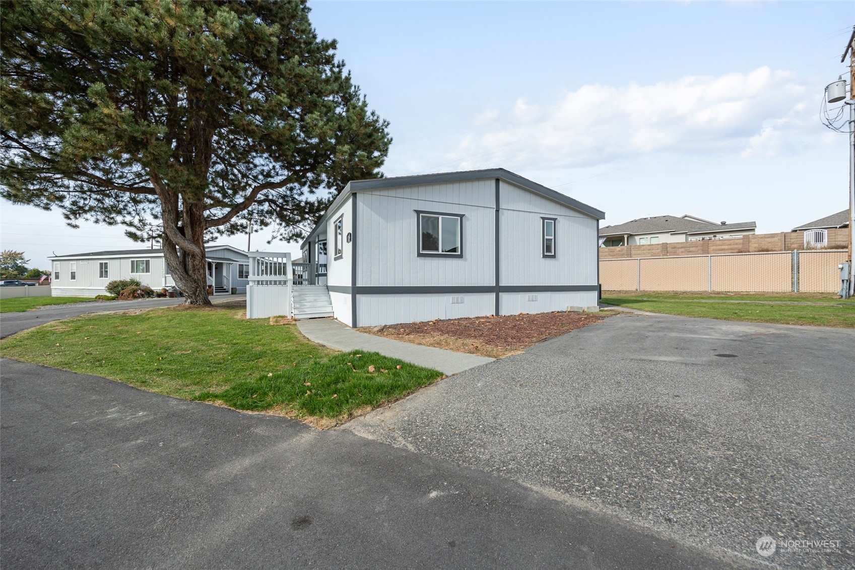 3517 N Road, Unit 115E Pasco, WA 99301 - Photo 26 of 26 a view of a house with a big yard and large tree