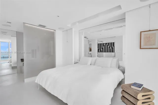 a bedroom with a bed and a lamp with the wooden floor