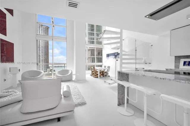 a living room with furniture and view of kitchen